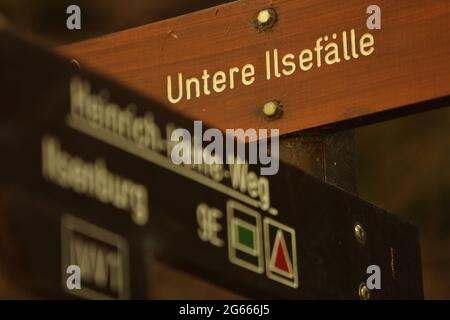 Ilsenburg, Deutschland. Juli 2021. Ein Wanderschild mit der Aufschrift 'untere Ilsefälle'. Das regnerische Wetter der letzten Tage hat dazu geführt, dass der Wasserstand der Ilse etwas anschwellen konnte. Die malerischen Wasserfälle im Ilse-Tal tragen zur besonderen Attraktivität des Weges bei. Der Dichter Heinrich Heine beschrieb die besonderen Eindrücke seiner Wanderung durch das Ilse-Tal im Jahr 1824 in seinem bekanntesten Werk "Harzreise". Quelle: Matthias Bein/dpa-Zentralbild/ZB/dpa/Alamy Live News Stockfoto