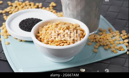 Sojamilch gemischt mit schwarzem Sesam in klarem Glas auf schwarzer Plattenmatte. Schwarzer Sesamsamen und Sojabohnen in einer Tasse. Schwarze Sojabohnenmilch mit Sesam. Er Stockfoto