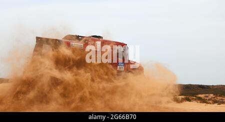 Die Rivalität zwischen Kamaz und Maz bei der Rallye. Der Sporttruck KAMAZ übersteht den schwierigen Teil der Strecke während des Rallye-Angriffs im Sand. DAS GOLD Stockfoto