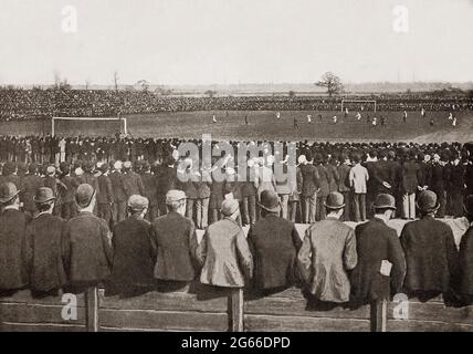 Ein Blick aus dem späten 19. Jahrhundert auf die Zuschauer (alle mit Kopfbedeckung) bei einem Fußballspiel auf dem Fallowfield Ground in Manchester, England, zwischen Everton und Wolverhampton Wanderers. Stockfoto