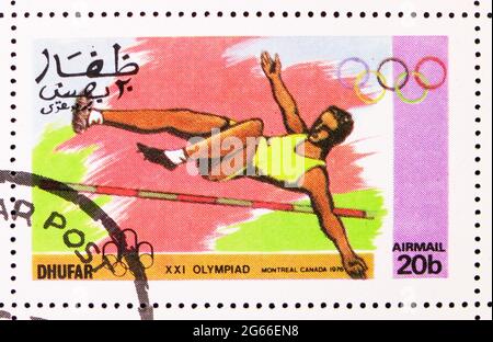 MOSKAU, RUSSLAND - 22. MÄRZ 2020: Briefmarke gedruckt in Cinderellas zeigt High Jump, XXI Olympiade Montreal Canada 1976, Dhufar Serie, um 1976 Stockfoto