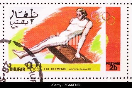 MOSKAU, RUSSLAND - 22. MÄRZ 2020: Briefmarke gedruckt in Cinderellas zeigt Gymnastik, XXI Olympiade Montreal Canada 1976, Dhufar Serie, um 1976 Stockfoto