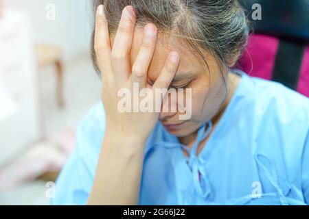 Asiatische Dame mittleren Alters Frau Patient Sorgen über Krankheit, Kopfschmerzen und fühlen sich traurig in der Krankenstation : gesunde medizinische Konzept Stockfoto