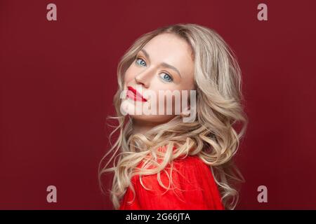 Porträt einer schönen glücklichen Frau mit blonden Haaren und Make-up. Schöne blonde Dame mit leuchtend rotem Lippenstift auf ihren Lippen. Stockfoto