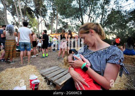Eine Frau stillt ihr Baby mit Kopfhörern, um sich vor dem Lärm der Musik beim Vida 2021 Festival zu schützen.Vida 2021, Ein internationales Festival, das drei Tage lang in der Stadt Vilanova i la Geldru (Barcelona) stattfindet und mit mehr als 50 Live-Performances Autorenmusik, Pop, Rock, elektronische Musik und Indie-Musik zusammenbringt. Das Festival Vida 2021 versucht, Musik, Natur, Meer, Kunst und Gastronomie in einem bukolischen Rahmen in mehreren Etappen am gleichen Ort zu erleben. (Foto von Ramon Costa / SOPA Images/Sipa USA) Stockfoto