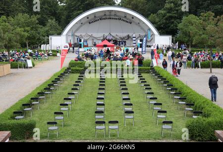 03. Juli 2021, Mecklenburg-Vorpommern, Warnemünde: Mit einer festlichen Veranstaltung im Kurhausgarten wird die 83. Warnemünder Woche eröffnet, einige Plätze bleiben frei. Die Veranstaltungen an Land werden in diesem Jahr mit einem deutlich reduzierten Programm aufgrund der Corona stattfinden. Bei den Segelwettbewerben auf dem Wasser wird es wieder Europameisterschaften und Deutsche Meisterschaften geben, es werden rund 500 Boote der verschiedenen Klassen erwartet. Foto: Bernd Wüstneck/dpa-Zentralbild/dpa Stockfoto