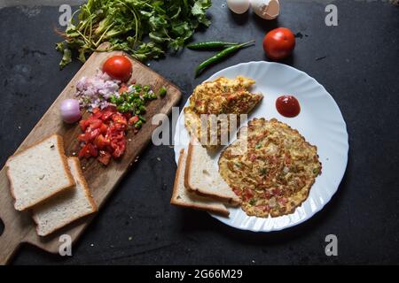 Beliebte indische Küche Masala Omelette serviert mit Brotscheiben. Stockfoto