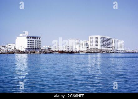 1972, Vereinigte Arabische Emirate Dubai.  Dhaus säumen den Bach vor National Bank of Dubai auf linken Seite.  Sonstige Büro- und Wohnhäuser auf rechten Seite. Stockfoto