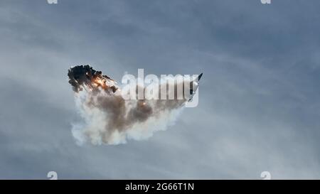 Flugzeugjäger fliegt und schießt Heißluftgewehre in den blauen Himmel. Der Kämpfer schießt während des Manövers Wärmestauben ab. Ein Kämpfer während einer Demonstration Stockfoto