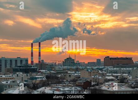 Ein Bild vom Sonnenuntergang über einigen Industrieschornsteinen in Moskau. Stockfoto