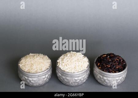 Drei Reissorten in einem silbernen Behälter. Auf einem grauen Hintergrund und einem Kopierbereich. Stockfoto