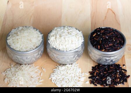 Drei Arten von thailändischem Reis in einem silbernen Behälter. Auf Holzhintergrund und Kopierraum. Stockfoto