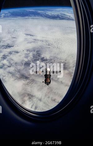 Blick auf ISS Progress Nachversorgung Schiff, Blick aus einem Passagierfenster auf die SpaceX Crew Dragon. Andockmanöver in der Nähe der Raumstation. Elemente von Stockfoto