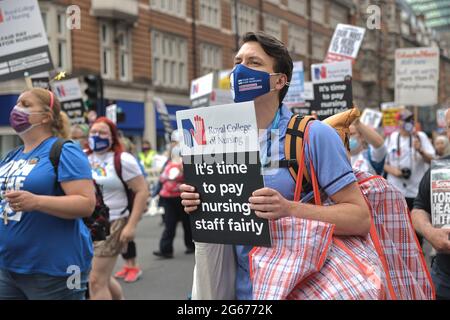 London, Großbritannien. Juli 2021. Eine Krankenschwester hält während der Demonstration ein Plakat mit der Forderung nach einer fairen Lohnerhöhung.am Wochenende des 73. Jahrestages des NHS in Großbritannien wurde eine landesweite Demonstration für eine faire Lohnerhöhung, Patientensicherheit und ein Ende der Privatisierung des NHS gefordert. Abgesehen von den verschiedenen Protesten, die vor verschiedenen NHS-Krankenhäusern in den Ländern stattfanden, marschierten NHS-Mitarbeiter in London vom University College London Hospital zur Downing Street, um die Regierung anzurufen, um auf ihre Forderungen zu reagieren. Kredit: SOPA Images Limited/Alamy Live Nachrichten Stockfoto