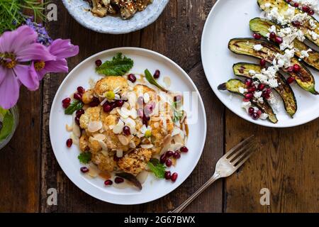 Vegane Gerichte mit Miso-Aubergine, geröstetem Blumenkohl und Baby-Zucchini Stockfoto