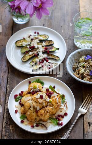 Vegane Gerichte mit Miso-Aubergine, geröstetem Blumenkohl und Baby-Zucchini Stockfoto