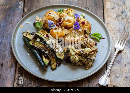 Vegane Mischung aus Miso Aubergine, geröstetem Blumenkohl und Baby Zucchini Stockfoto