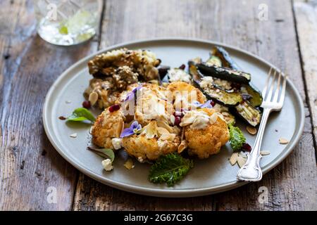 Vegane Mischung aus Miso Aubergine, geröstetem Blumenkohl und Baby Zucchini Stockfoto