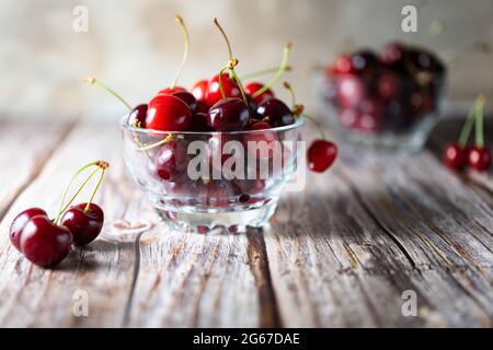 Augen nivelliert Glas Schüssel mit Kirschen auf Holzhintergrund Stockfoto