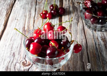 Augen nivelliert Glas Schüssel mit Kirschen auf Holzhintergrund Stockfoto