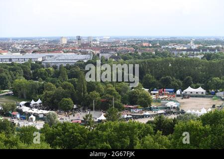 München, Deutschland. Juli 2021. Vom Tollwood Festival kann man vom Olympiaberg die Klänge einer Band hören, die auf dem Festivalgelände spielt. Bei warmen Temperaturen und angenehmem Sommerwetter können Sie das Wochenende im Olympiapark genießen. Quelle: Felix Hörhager/dpa/Alamy Live News Stockfoto