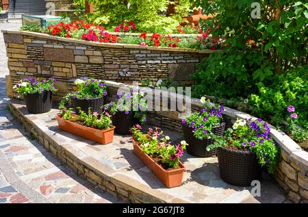 Landschaftsgestaltung von schönen Hausgarten, Landschaftsgestaltung mit Stützmauern und Blumenbeete in Wohnhaus Hinterhof. Wunderschöne Landschaft im Freien Stockfoto