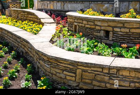 Landschaftsgestaltung von schönen Hausgarten, Landschaftsgestaltung mit Stützmauern und Blumenbeete in Wohnhaus Hinterhof. Wunderschöne Landschaft im Freien Stockfoto