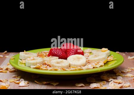 Erdbeere, Banane und Getreide auf einer grünen Schale Stockfoto