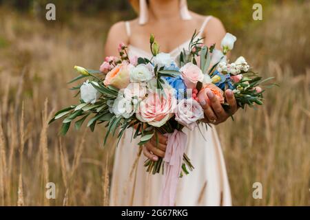 Ein zartes und sehr schönes Brautstrauß aus Rosen, Grün, Onustoma und Hortensien in Brauthänden. Braut trendige Floristen in Pastellfarben. Hand Stockfoto