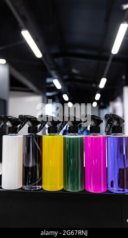 Bunte Sprühflaschen mit verschiedenen chemischen Flüssigkeiten Stockfoto