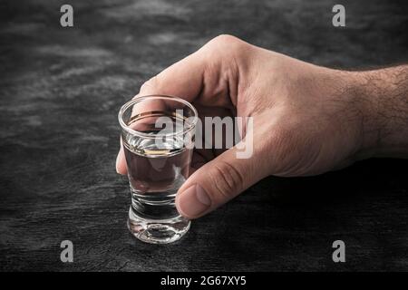 Hand mit einem Glas Wodka. Alkoholismus-Konzept. Stockfoto