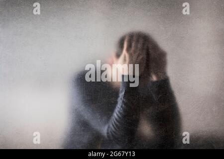 Depression. Gebrochener Mann hinter einem staubigen zerkratzt Glas. Stockfoto