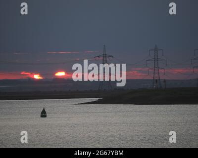 Elmley, Kent, Großbritannien. Juli 2021. UK Wetter: Sonnenuntergang über der Swale von der Nähe von Elmley, Kent aus gesehen. Kredit: James Bell/Alamy Live Nachrichten Stockfoto