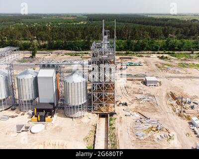 Luftaufnahme des riesigen modernen Getreideaufzugs. Lagerung von Lebensmitteln, Gebäude in Arbeit. Silofarm. Entwicklung der Agrarindustrie. Stockfoto