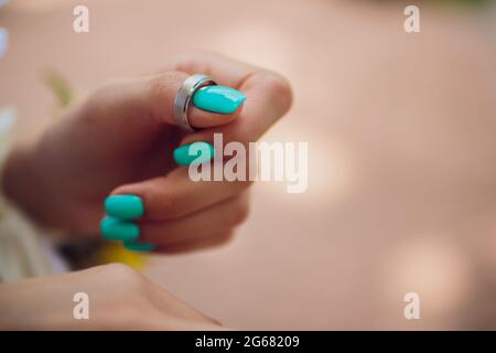 Paar Hochzeitsringe aus Weißgold mit Diamanten im Damenring. Silbernes Eheringe-Band mit Edelsteinen auf minimalistischem grauen Hintergrund mit Schattendagen Stockfoto