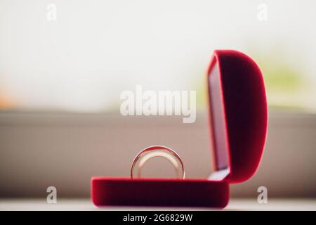 Paar Hochzeitsringe aus Weißgold mit Diamanten im Damenring. Silbernes Eheringe-Band mit Edelsteinen auf minimalistischem grauen Hintergrund mit Schattendagen Stockfoto