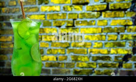 Grüne Limonade an der Bar, grüner alkoholischer Cocktail, Nahaufnahme mit Eis. Stockfoto