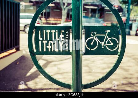 Nahaufnahme eines modernen grünen Metall-Fahrradträgers mit Little Italy-Logo und ausgeschnittener Kunst des Fahrrads auf dem Bürgersteig in der Nähe des Hafens in San Diego, CA Stockfoto