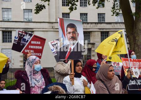 London, Großbritannien. Juli 2021. Ein Protestler hält ein Bild des ehemaligen ägyptischen Präsidenten, Mohamed Mursi, während der Protestierenden, die sich vor der Downing Street zum Jahrestag des Putsches in Ägypten im Jahr 2013 versammelten. (Foto: Vuk Valcic/SOPA Images/Sipa USA) Quelle: SIPA USA/Alamy Live News Stockfoto