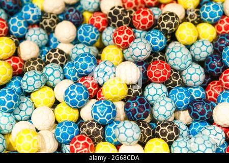 Kauen Süßigkeiten in Form eines Fußballs in der Masse, Draufsicht als Hintergrund. Leckere Süßigkeiten Stockfoto