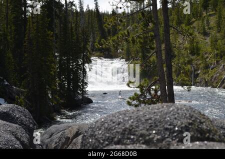 Spätfrühling im Yellowstone National Park: Blick flussaufwärts auf die Lewis Falls auf dem Lewis River neben der South Entrance Road Stockfoto