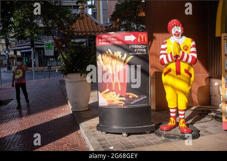 Der Clown von McDonald's, der den traditionellen thailändischen „wai“ (Gruß) vor einer McDonald's-Niederlassung in der Gegend von Wang Burapha, Bangkok, Thailand, aufführt Stockfoto