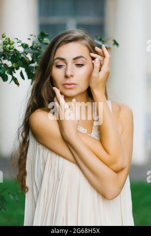 Eine junge Frau berührt ihr Gesicht mit ihren Händen. Das Konzept von Fürsorge und Selbstliebe Stockfoto