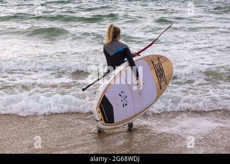 Poole, Dorset, Großbritannien. Juli 2021. Wetter in Großbritannien: bewölkt und windig mit sonnigen Intervallen an den Stränden von Poole. Paddlebarder bei Branksome Chine. Quelle: Carolyn Jenkins/Alamy Live News Stockfoto