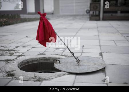 Zerbrochene und offene Kanalabdeckung aus der Nähe. Konzept für Straßenreparaturen Stockfoto