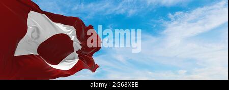 Offizielle Flagge der Präfektur Kumamoto, die am sonnigen Tag im Wind auf Fahnenmasten gegen den Himmel mit Wolken schwenkt. Japan Patriotisches Konzept. 3d-Illustration. Stockfoto