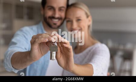 Nahaufnahme glückliches junges Paar Hausbesitzer umarmt und zeigt Schlüssel Stockfoto