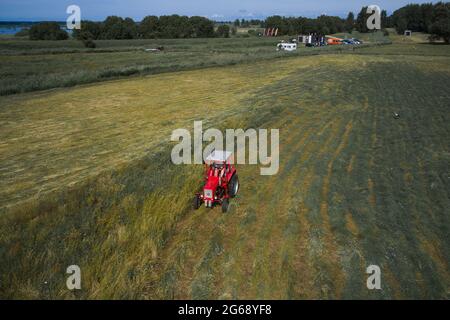 Kleine Landwirtschaft mit Traktor und Pflug im Feld Stockfoto