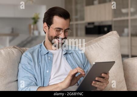 Nahaufnahme lächelnder Mann in Brille mit Tablet zu Hause Stockfoto