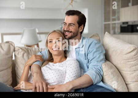 Verträumt glücklich junges Paar umarmt, entspannen auf der Couch zusammen Stockfoto